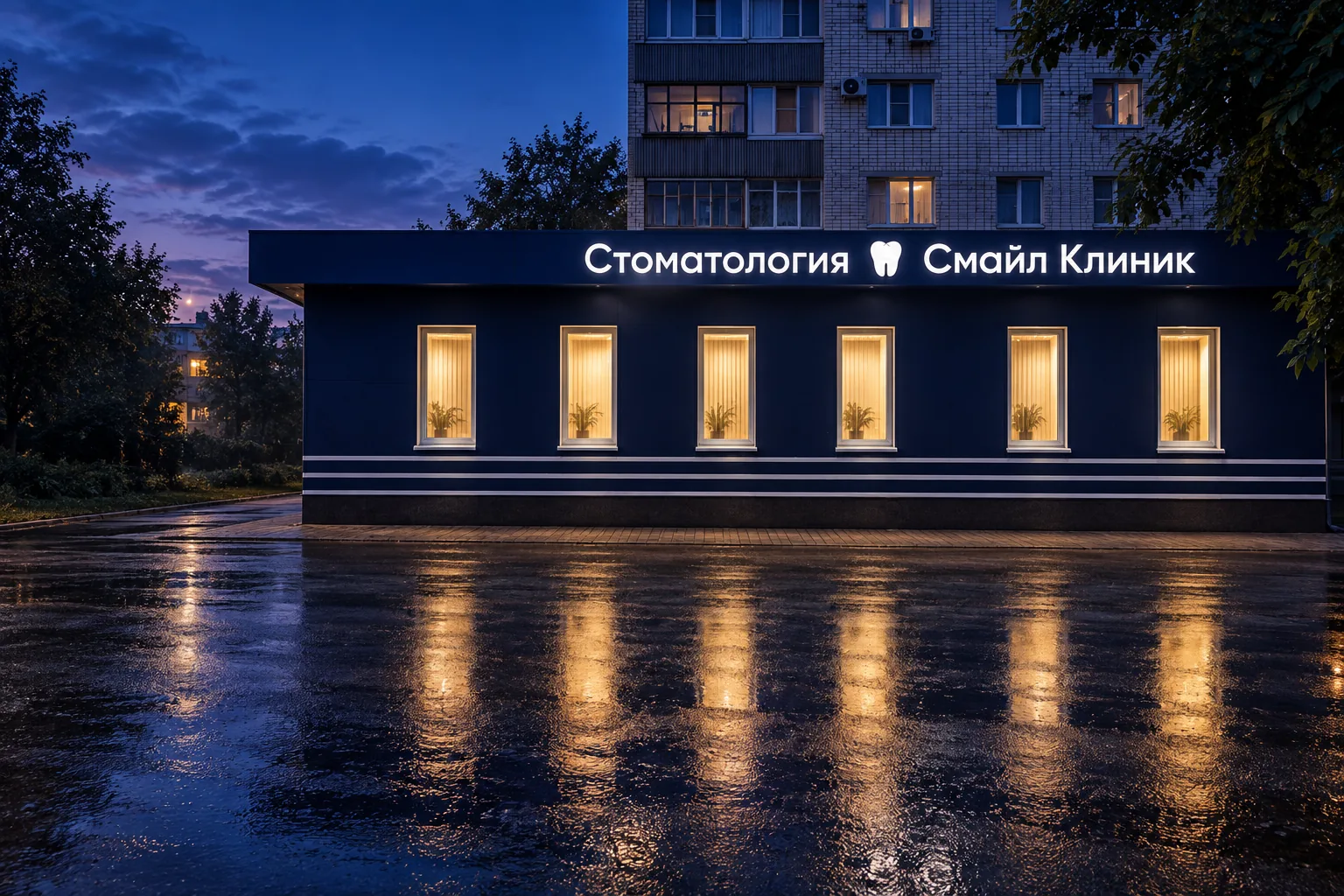 Синий фасад клиники вечером, над окнами светится вывеска «Стоматология Смайл Клиник»